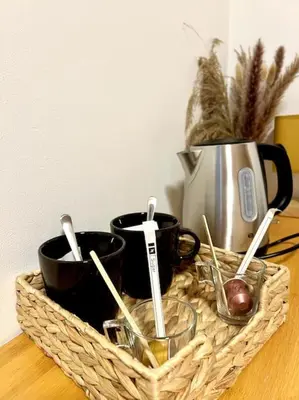 a basket with coffee cups and utensils on a table at Les chambres de la bastide - 201 in Carcassonne