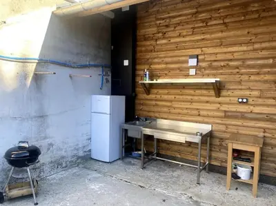 a kitchen with a refrigerator and a table and a chair at L'AAppartement in Montréal
