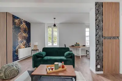 a living room with a green couch and a table at Cocon de la Place in Villefranche-de-Lauragais
