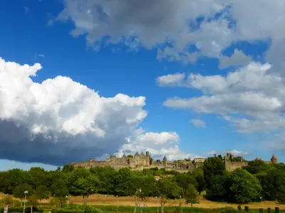 a castle on top of a hill under a cloudy sky at Carcassonne Guesthouse in Carcassonne