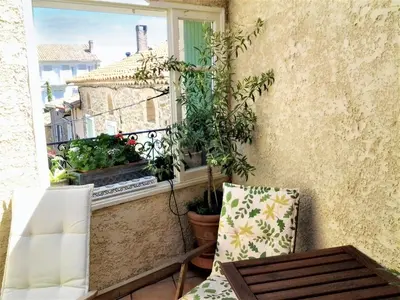 a balcony with a chair and a table and a window at Maison intime à Pouzols-Minervois avec jardin et parking in Pouzols-Minervois