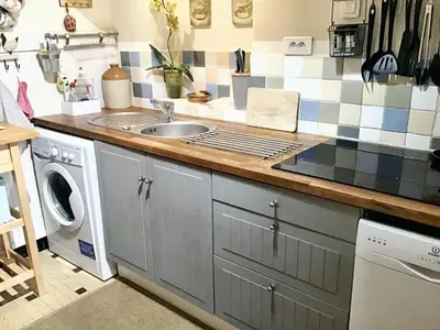 a kitchen with a sink and a washing machine at Maison intime à Pouzols-Minervois avec jardin et parking in Pouzols-Minervois
