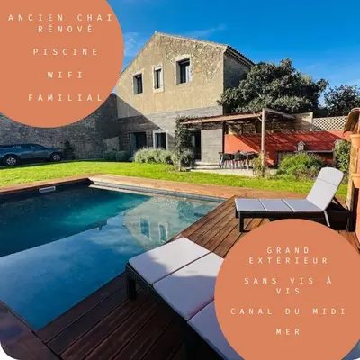 a swimming pool in front of a house at Ancien chai rénové avec piscine in Paraza