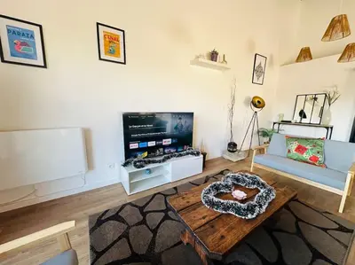 a living room with a couch and a tv at Ancien chai rénové avec piscine in Paraza