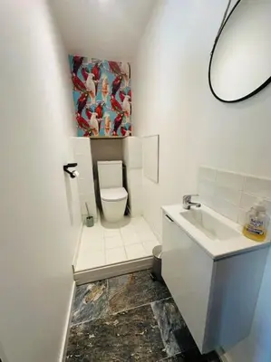 a white bathroom with a toilet and a sink at Ancien chai rénové avec piscine in Paraza