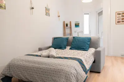 a bedroom with a bed and a couch at Spacieux T2 au centre ville avec parking et climatisation in Carcassonne