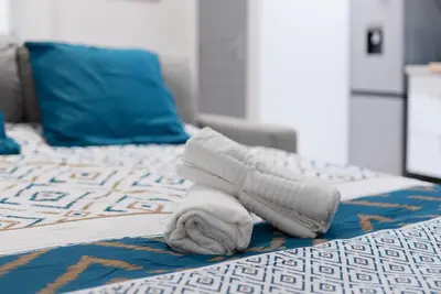 a towel laying on top of a bed at Spacieux T2 au centre ville avec parking et climatisation in Carcassonne
