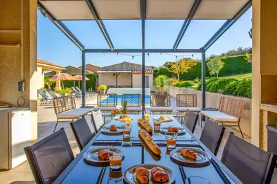 a dining room with a table with food on it at Villa Loupia by Villa Plus in Loupia