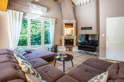 a living room with a large couch and a fireplace at Villa Loupia by Villa Plus in Loupia
