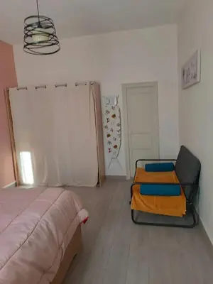a bedroom with a bed and a chair in it at Appartement spacieux à Lézignan-Corbières de 75 m² in Lézignan-Corbières