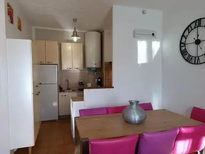 a kitchen with a table and a clock on the wall at Appartement spacieux à Lézignan-Corbières de 75 m² in Lézignan-Corbières