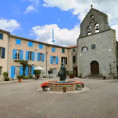 a large stone building with a statue in front of it at Les lits de Montbel gîte in Sonnac-sur-lʼHers
