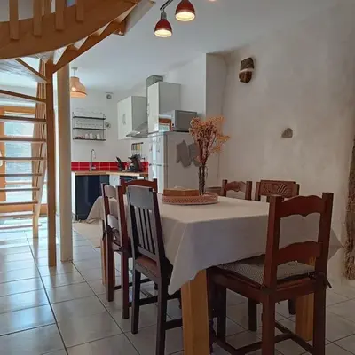 a kitchen and dining room with a table and chairs at Les lits de Montbel gîte in Sonnac-sur-lʼHers