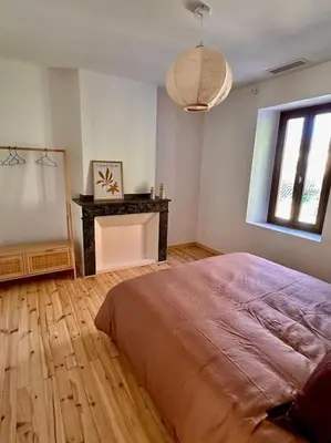 a bedroom with a bed and a table and a window at Maison Henriette - Au plus près de la Cité Médiévale in Carcassonne