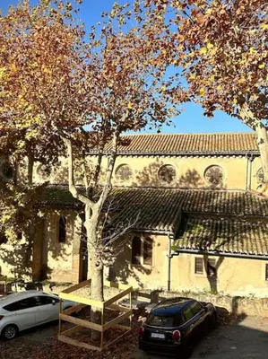 a car parked in front of a building with a tree at Maison Henriette - Au plus près de la Cité Médiévale in Carcassonne