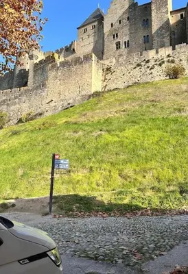 a castle sitting on top of a grassy hill at Maison Henriette - Au plus près de la Cité Médiévale in Carcassonne