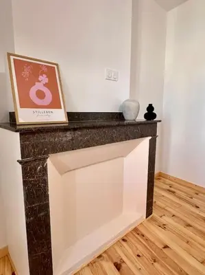 a living room with a marble fireplace with a picture at Maison Henriette - Au plus près de la Cité Médiévale in Carcassonne