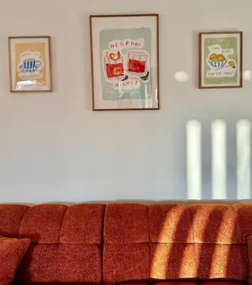 three pictures on a wall above a red couch at Maison Henriette - Au plus près de la Cité Médiévale in Carcassonne