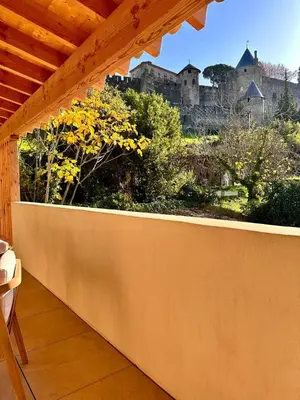 a balcony with a view of a castle in the background at Maison Henriette - Au plus près de la Cité Médiévale in Carcassonne