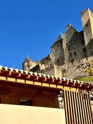 a large castle sitting on top of a building at Maison Henriette - Au plus près de la Cité Médiévale in Carcassonne