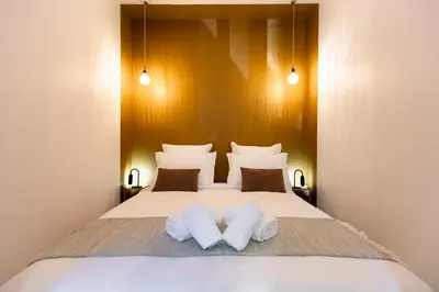 a bedroom with a bed with two towels on it at Le Boréal - Studio Confort Lit Queen Size in Mazamet