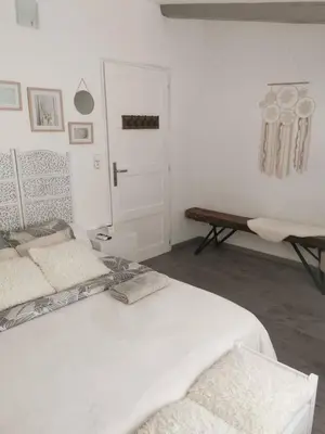 a white bedroom with a bed and a door at Chez Nathalie&Maxime in Sorèze