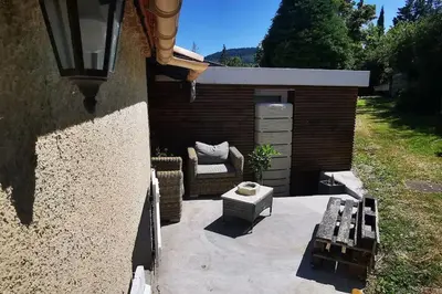 a fence with a table and a chair next to a tree at Chez Nathalie&Maxime in Sorèze
