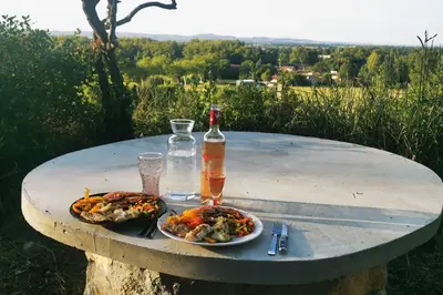 a table and chairs sitting next to a fence at Chez Nathalie&Maxime in Sorèze