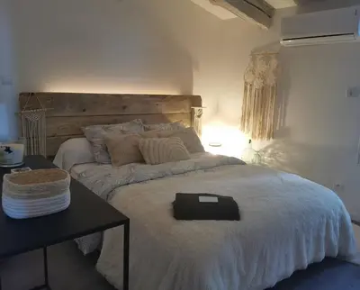 a bedroom with a large bed with a black table at Chez Nathalie&Maxime in Sorèze