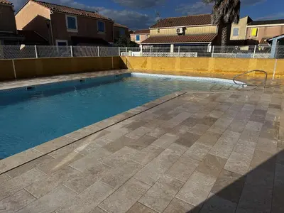 a swimming pool with blue water in a yard at Joli pavillon - À deux pas de la plage du Grazel GA090-024 in Gruissan
