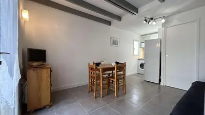 a living room with a dining room table and a television at Joli pavillon - À deux pas de la plage du Grazel GA090-024 in Gruissan