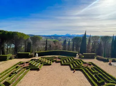 a large formal garden with a view of the mountains at Château de Roques in Teilhet