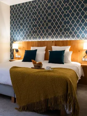 a bedroom with a large bed with a brown blanket at Château de Roques in Teilhet