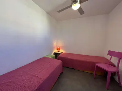 a room with two beds and a table with a lamp at Front de plage du Grazel - Piscine et parking GN500-014 in Gruissan