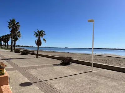 a street light on a sidewalk next to the beach at Front de plage du Grazel - Piscine et parking GN500-014 in Gruissan