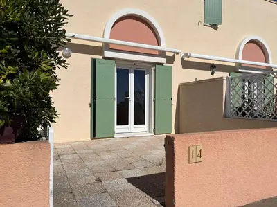 a house with green and white doors on it at Front de plage du Grazel - Piscine et parking GN500-014 in Gruissan