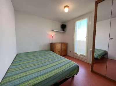 a small bedroom with a bed and a window at Front de plage du Grazel - Piscine et parking GN500-014 in Gruissan