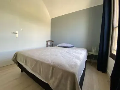 a bedroom with a bed with a chair and a window at Vue panoramique sur le port - Appartement 3 pièces GN110-C44 in Gruissan