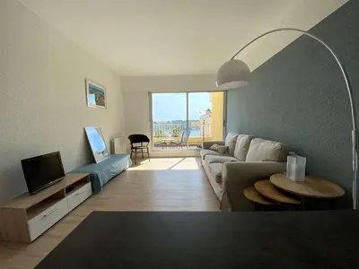a living room with a couch and a tv at Vue panoramique sur le port - Appartement 3 pièces GN110-C44 in Gruissan