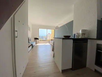 a room with a kitchen and a living room with a table at Vue panoramique sur le port - Appartement 3 pièces GN110-C44 in Gruissan