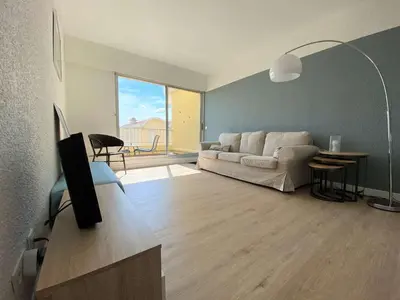 a living room with a white couch and a tv at Vue panoramique sur le port - Appartement 3 pièces GN110-C44 in Gruissan