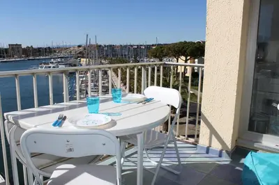 a table on a balcony with a view of a harbor at Appartement avec terrasse et jolie vue sur port GN580-033 in Gruissan