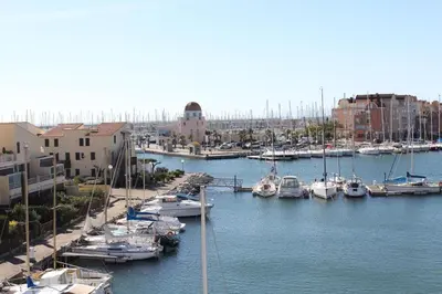a group of boats docked in a harbor with buildings at Appartement avec terrasse et jolie vue sur port GN580-033 in Gruissan