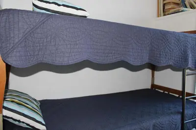 a bed with a blue blanket on top of it at Appartement avec terrasse et jolie vue sur port GN580-033 in Gruissan
