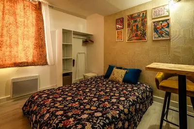 a bedroom with a bed and a table in it at Studio Soleil d'Azur in Narbonne