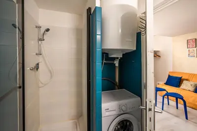 a bathroom with a washing machine and a shower at Studio Soleil d'Azur in Narbonne