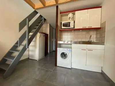 a kitchen with a washing machine and a staircase at Appartement dernier étage à 300 m de la plage GN020-238 in Gruissan