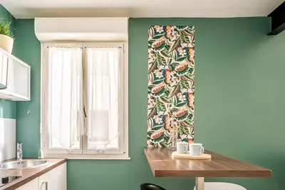 a kitchen with green walls and a window and a table at Joli studio Narbonne in Narbonne