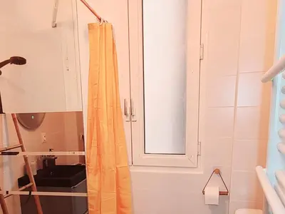 a bathroom with a shower curtain and a mirror at Le Marceau Cour Extérieure in Narbonne