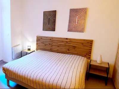 a bedroom with a bed and two pictures on the wall at Le Marceau Cour Extérieure in Narbonne
